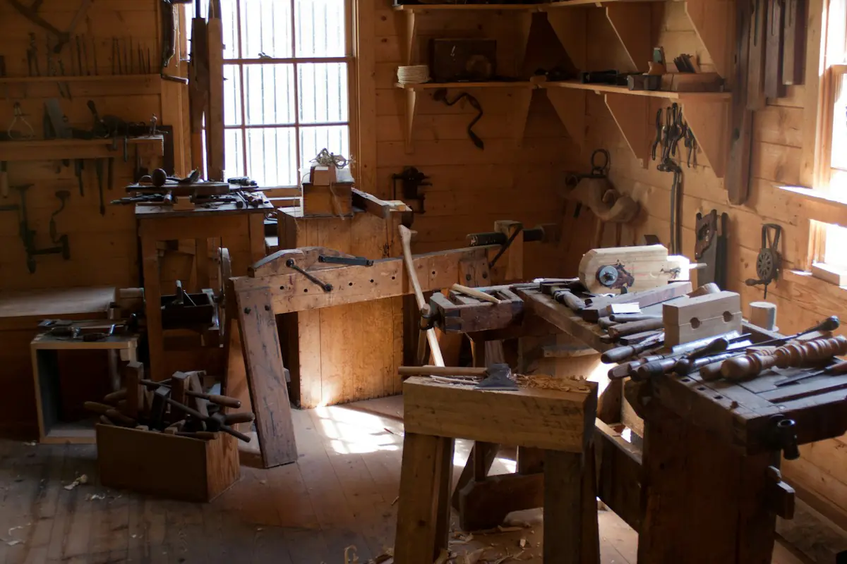 L’atelier : établis en bois, outils à main et lumière du jour par la fenêtre