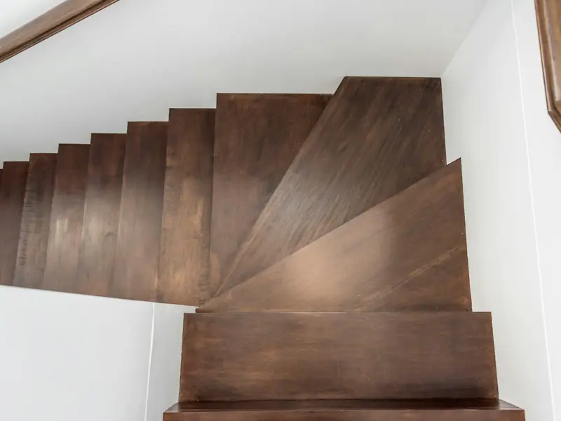 Escalier quart tournant en bois foncé, vu d’en haut
