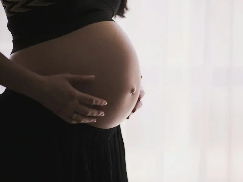 Mains posées sur un ventre de femme enceinte