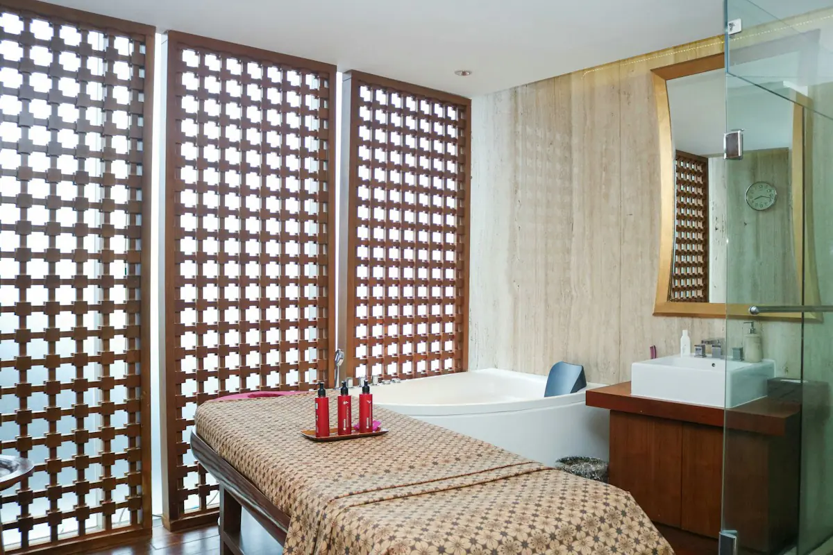 Cabine de soin : table de massage, baignoire et paravents ajourés