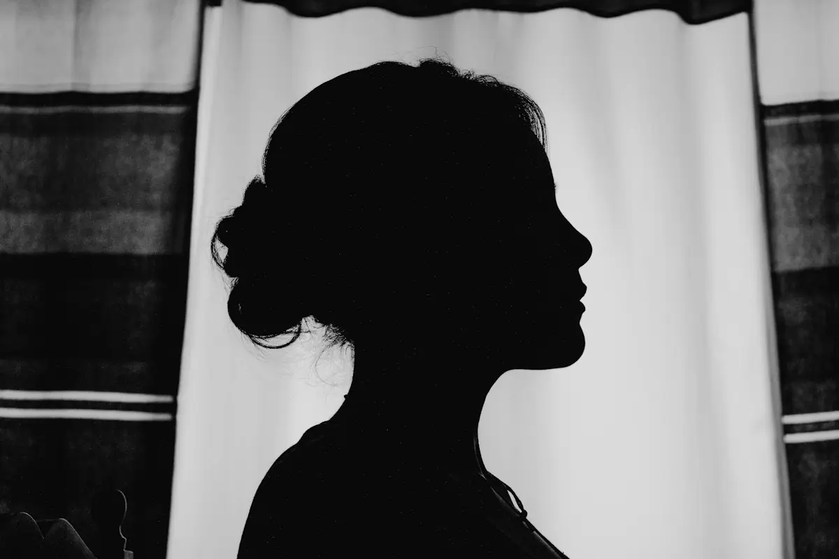 Profil d’une femme en ombre chinoise devant un rideau