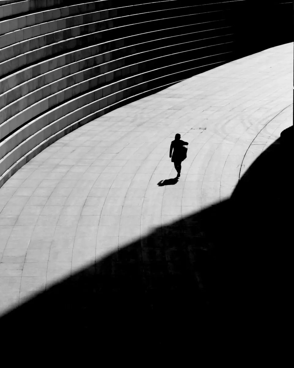 Passant minuscule sur une esplanade aux lignes courbes